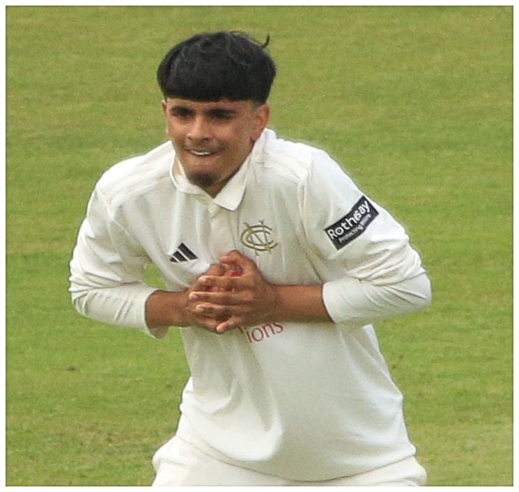 Farhan Ahmed holding a red cricket ball while playing for Nottinghamshire